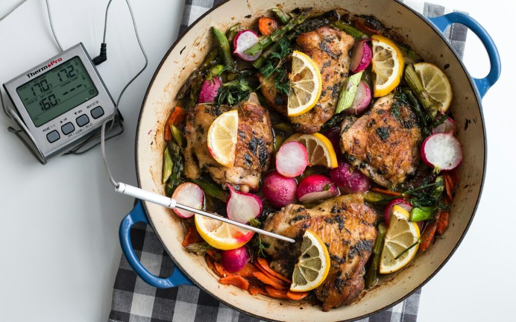 Digital food thermometer next to a cooked dish