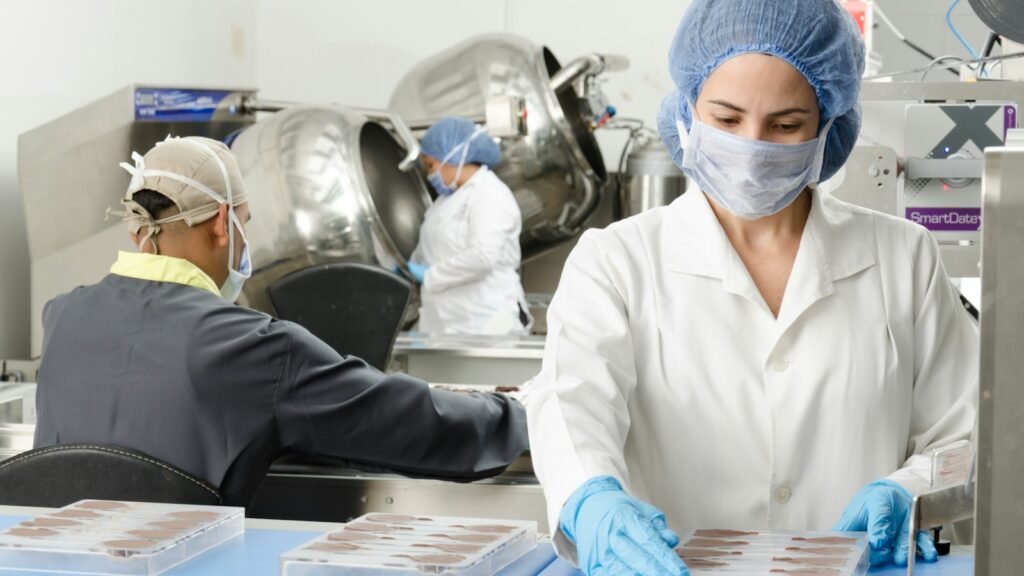 Food worker wearing a hairnet, mask and gloves