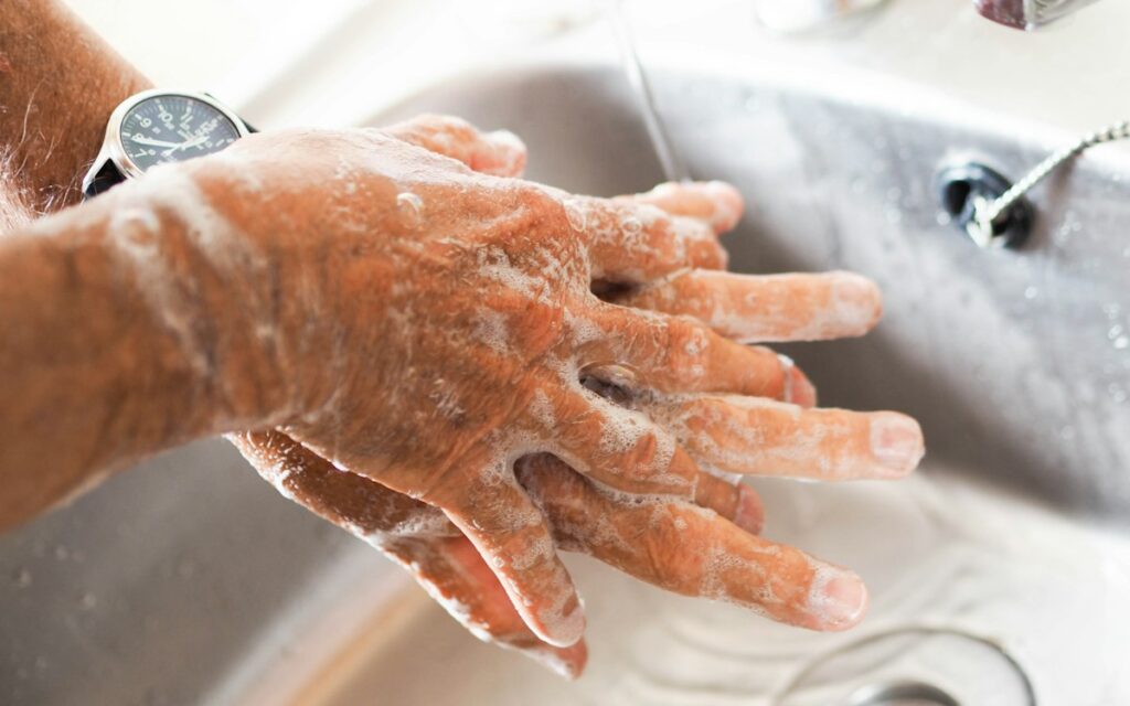 Hands being washed with soap under running water