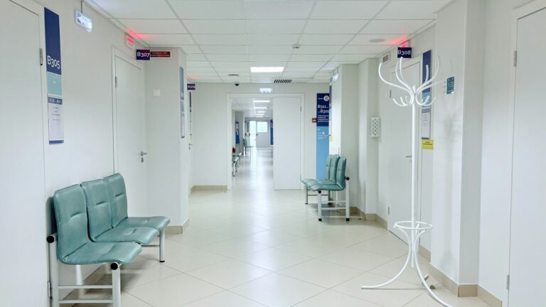 Clean clinic corridor with waiting seats and treatment room doors