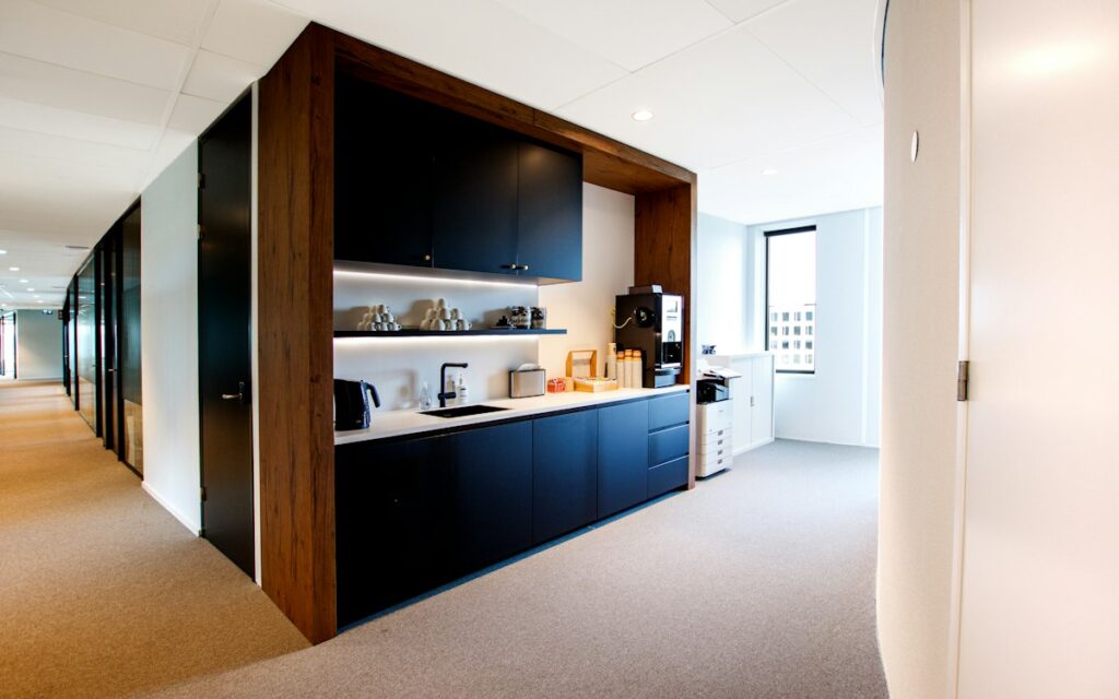 Office corridor leading to a kitchen area