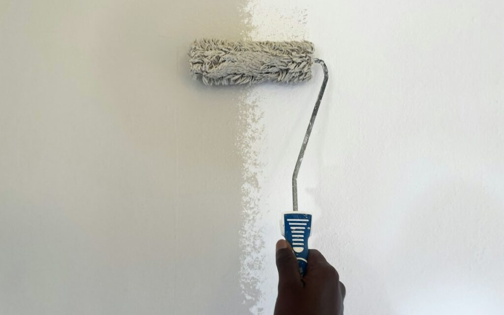 Paint roller freshening up a wall