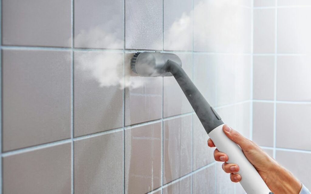 Steam cleaner being used on bathroom tiles