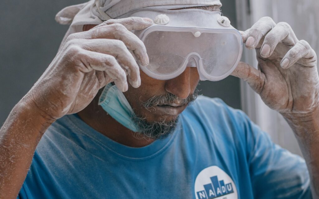Worker wearing safety goggles and a face mask