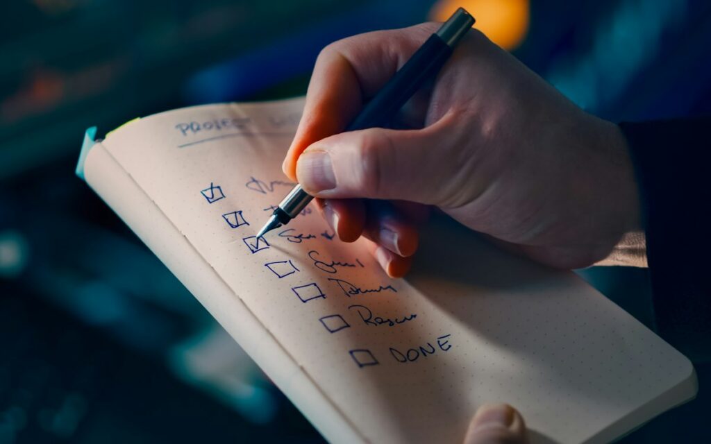 Person writing notes on a checklist
